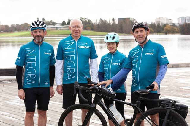 Four people in cycling gear with Integra-branded cycle wear