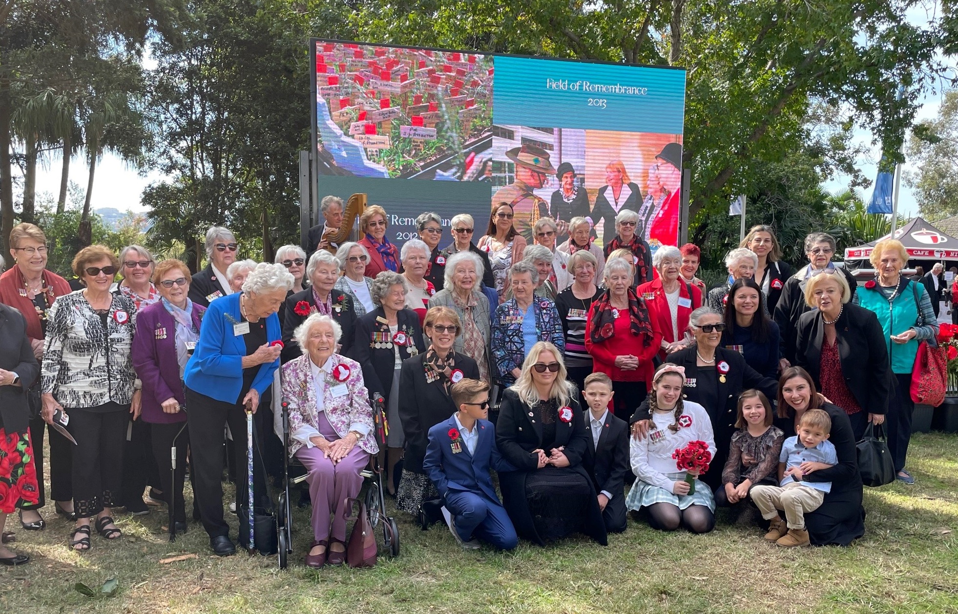 About 30 women in park posing in front of banner saying Field of Remembrance