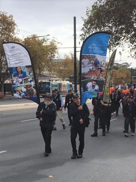 A group of people march down a street with banners