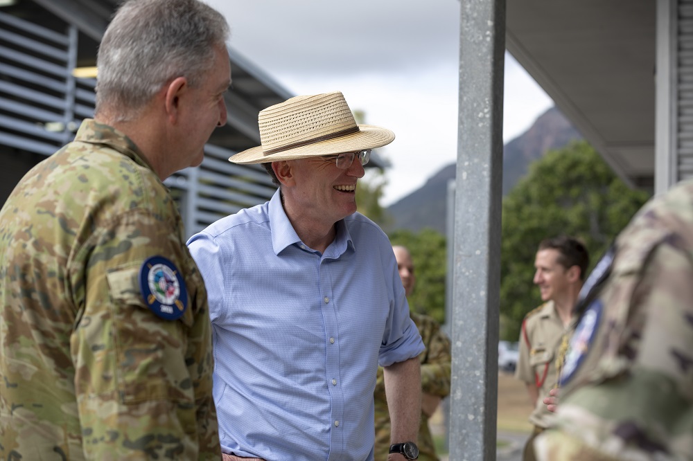 Middle-aged civilian man smiling with people in Army uniforms