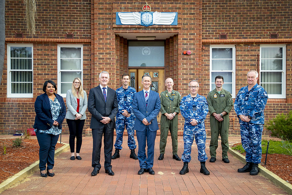 Nine people standing outside RAAF building, half of them in uniform