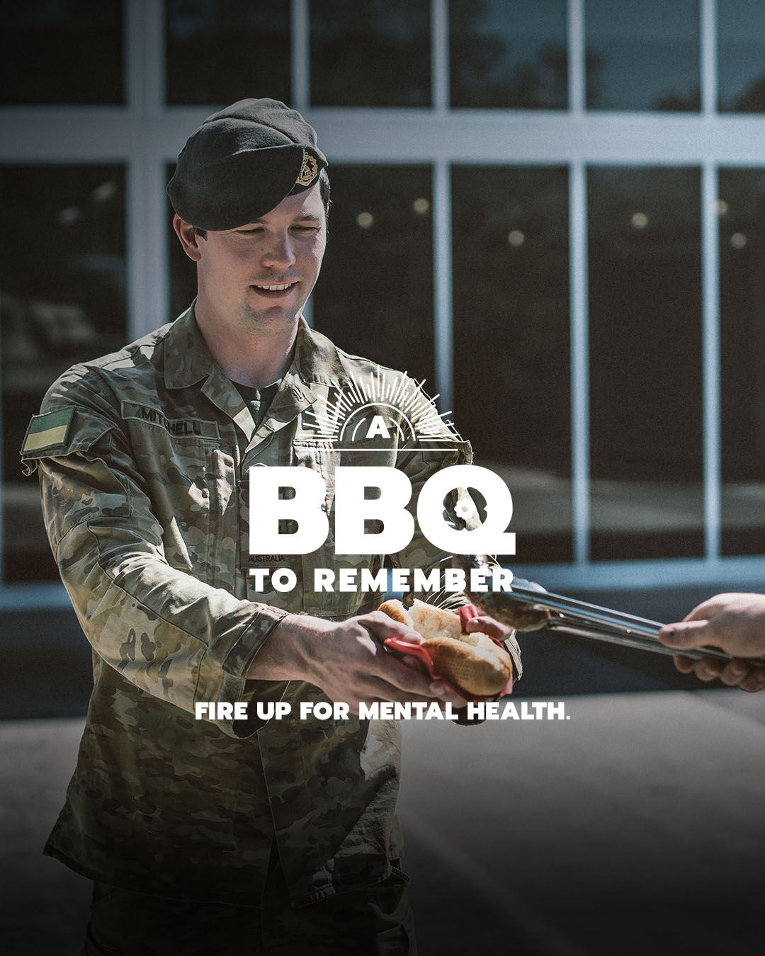 Soldier receiving a sausage sandwich with slogan: A BBQ to remember