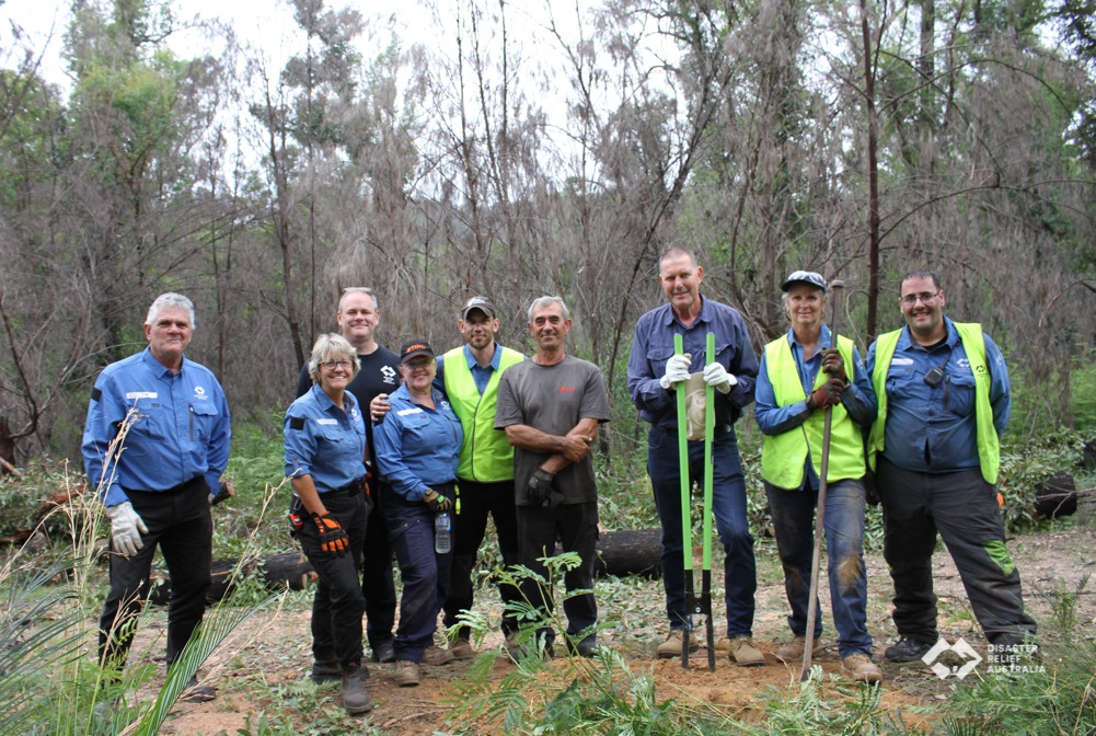 Nine people in the bush posing for camera