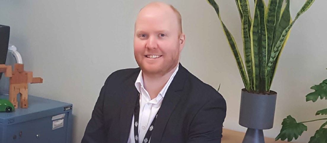 Smiling man sitting at a desk in an office