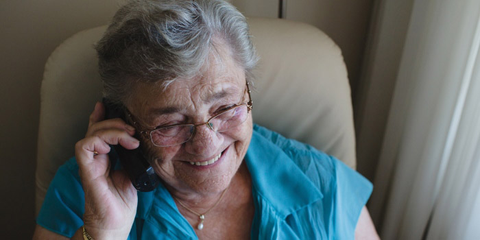 Elderly woman talking over a mobile phone.