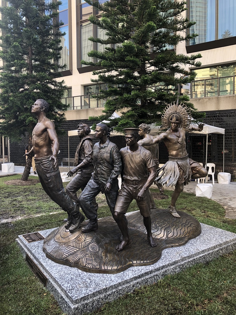 Bronze sculpture with five Indigenous men in various uniforms and traditional clothing