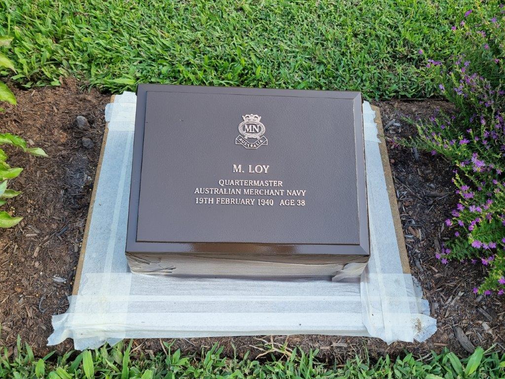 Restored bronze plaque surrounded by masking tape