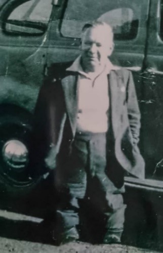 Man standing in front of car with boots just below his knees