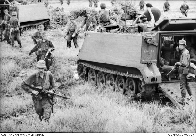 During Operation Smithfield, armoured personnel carriers of 1 APC Squadron and troops on foot sweep along in pursuit of retreating Viet Cong in Phuoc Tuy Province after the Battle of Long Tan.