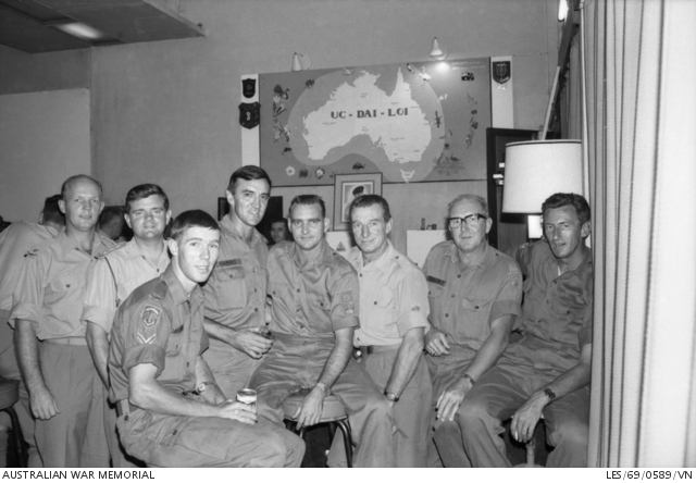 Black and white photo of eight men in uniform posing for camera