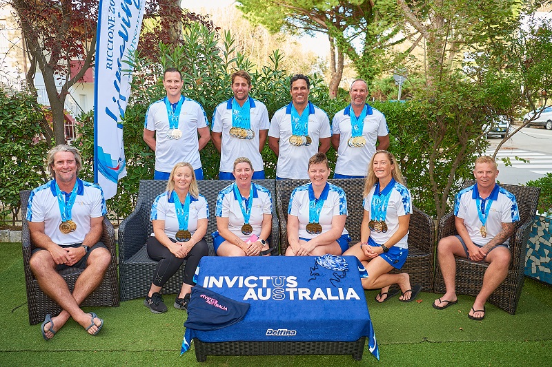 Ten men and women wearing medals pose for photo