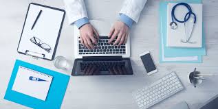 image of desk with person using laptop with office stationery on the desk