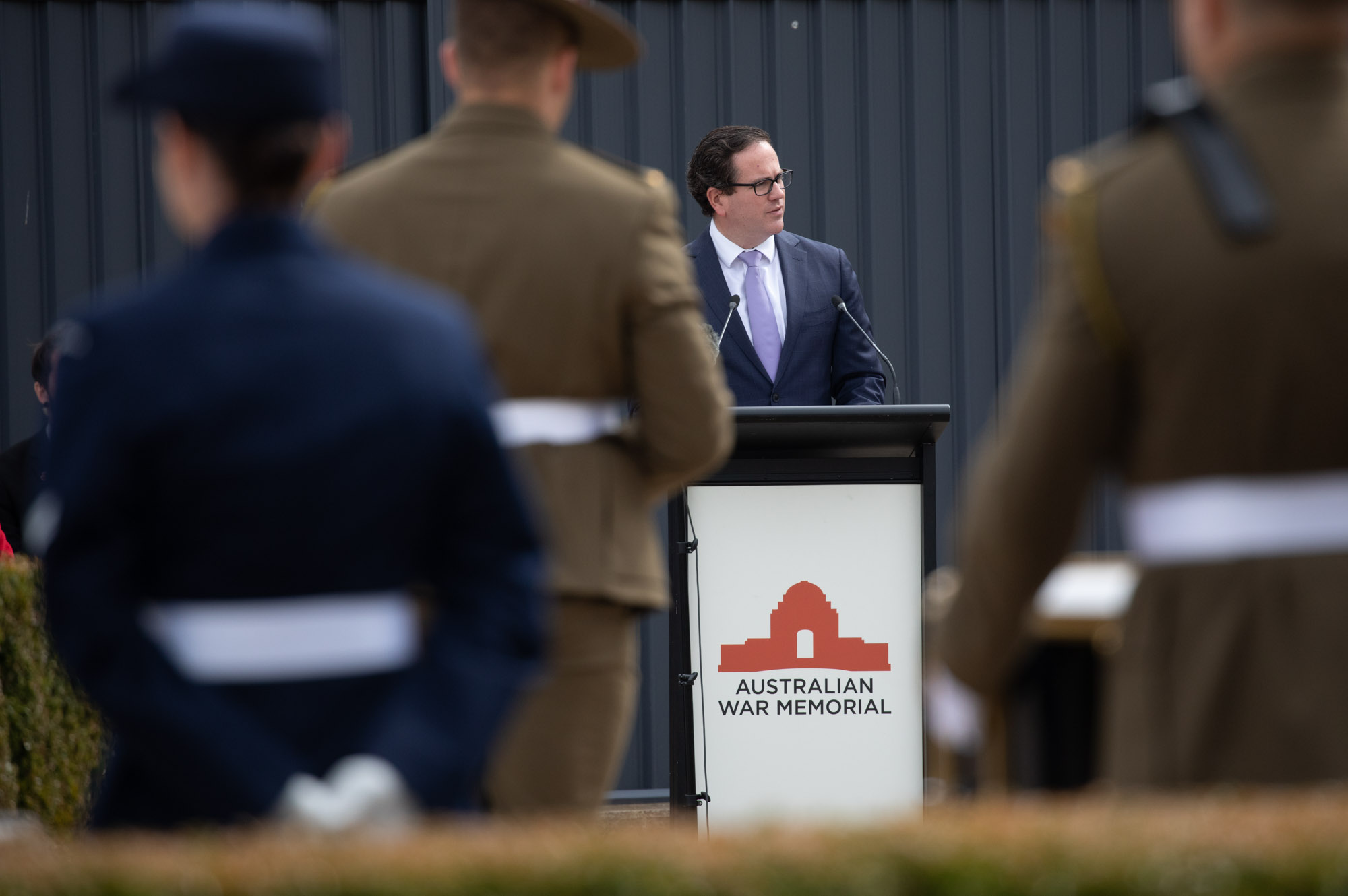 Man in suit addresses ADF personnel at Australian War Memorial lectern