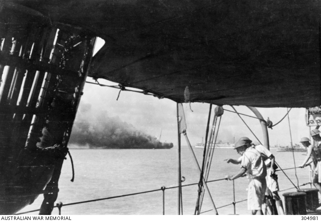 Crew members of the depot ship HMAS Platypus survey the harbour shortly after the Japanese air raid on Darwin