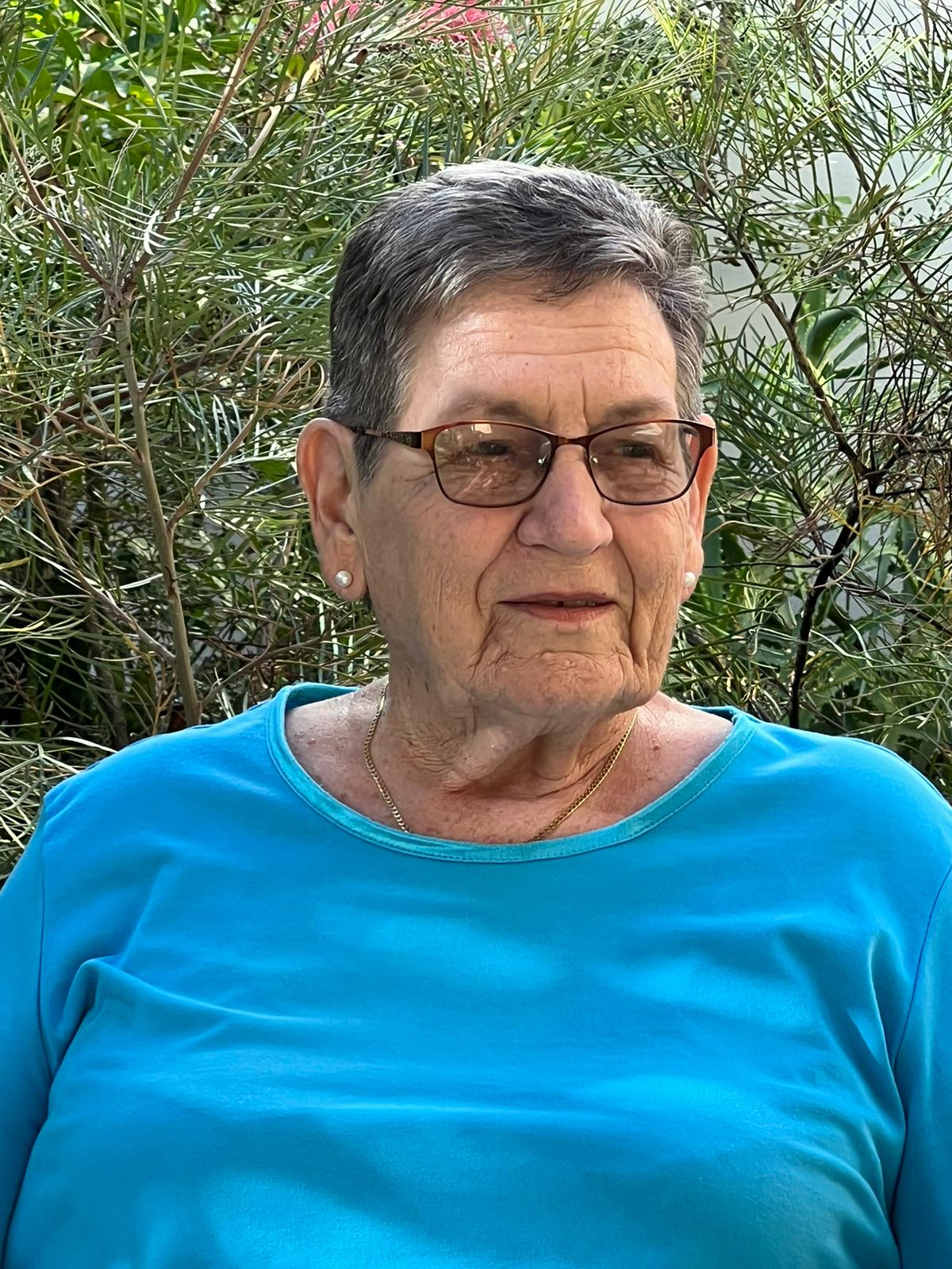 Portrait of older woman with bush in background