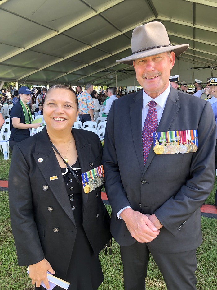 Aboriginal woman standing next to white middle-aged man, both wearing medals