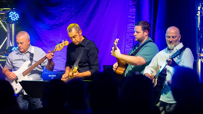 Four men playing the guitar