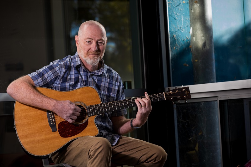 Middle-aged man playing the guitar