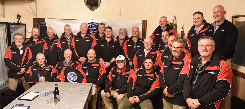 About 30 people, mostly older men, posing for photo