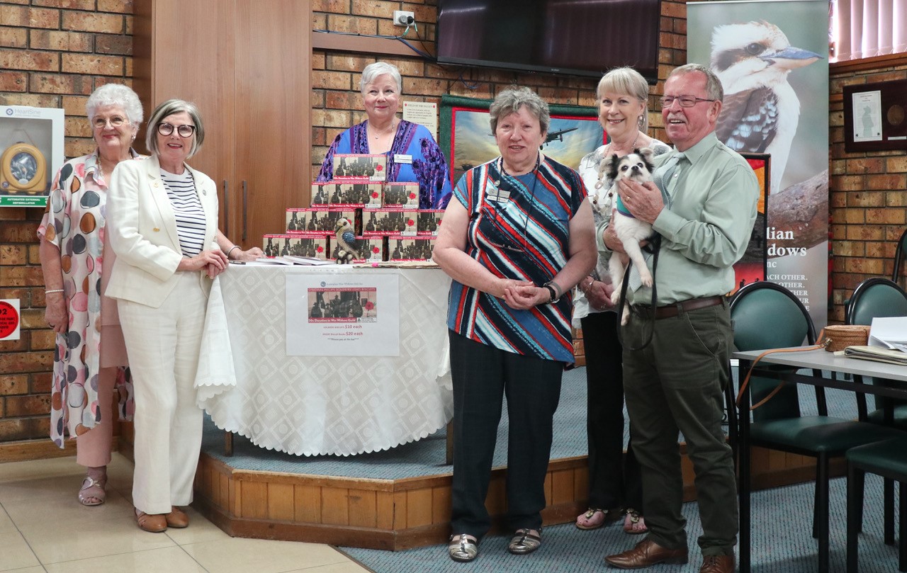 from left: Vice President Jan Milham, President Diane Carr, Secretary Maria Barclay, Helen Adamson, Julie Broome, and South Australia’s Minister for Veterans’ Affairs Geoff Brock holding ‘Bilbo’ at the Soldiers’ Biscuits display.