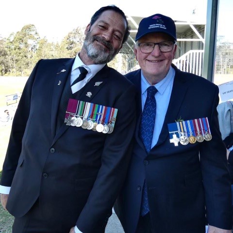 Two men posing for photo, one wearing the Victoria Cross, the other the George Cross