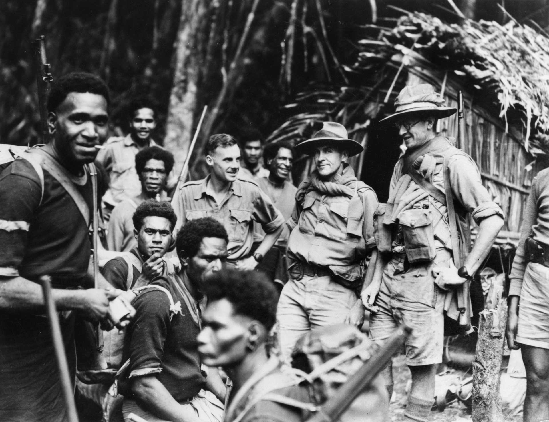 New Guinean carriers meet Australian Officers at a rest spot on the Kokoda Track, August 1942 (AWM 150655, Photographer Damien Parer)