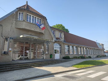 The old grey museum building with French and Australian flags hanged over the main entry