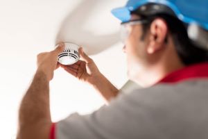 man installing a smoke alarm