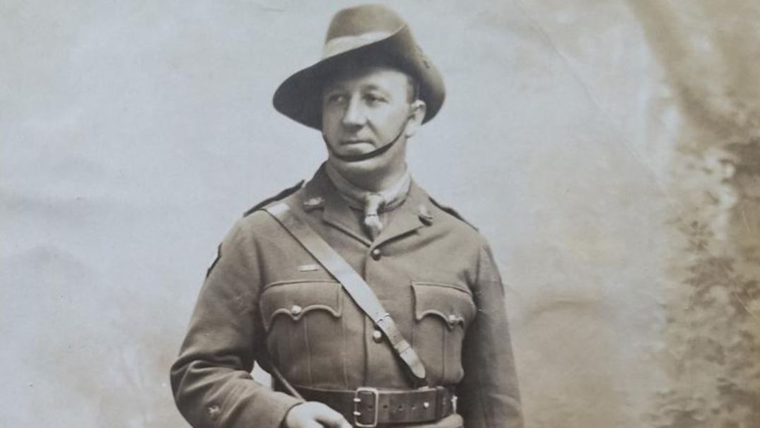 Black and white studio photo of man wearing officer's uniform