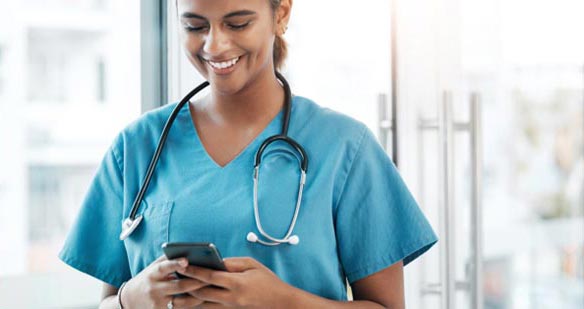 A young female doctor checking her mobile phone.