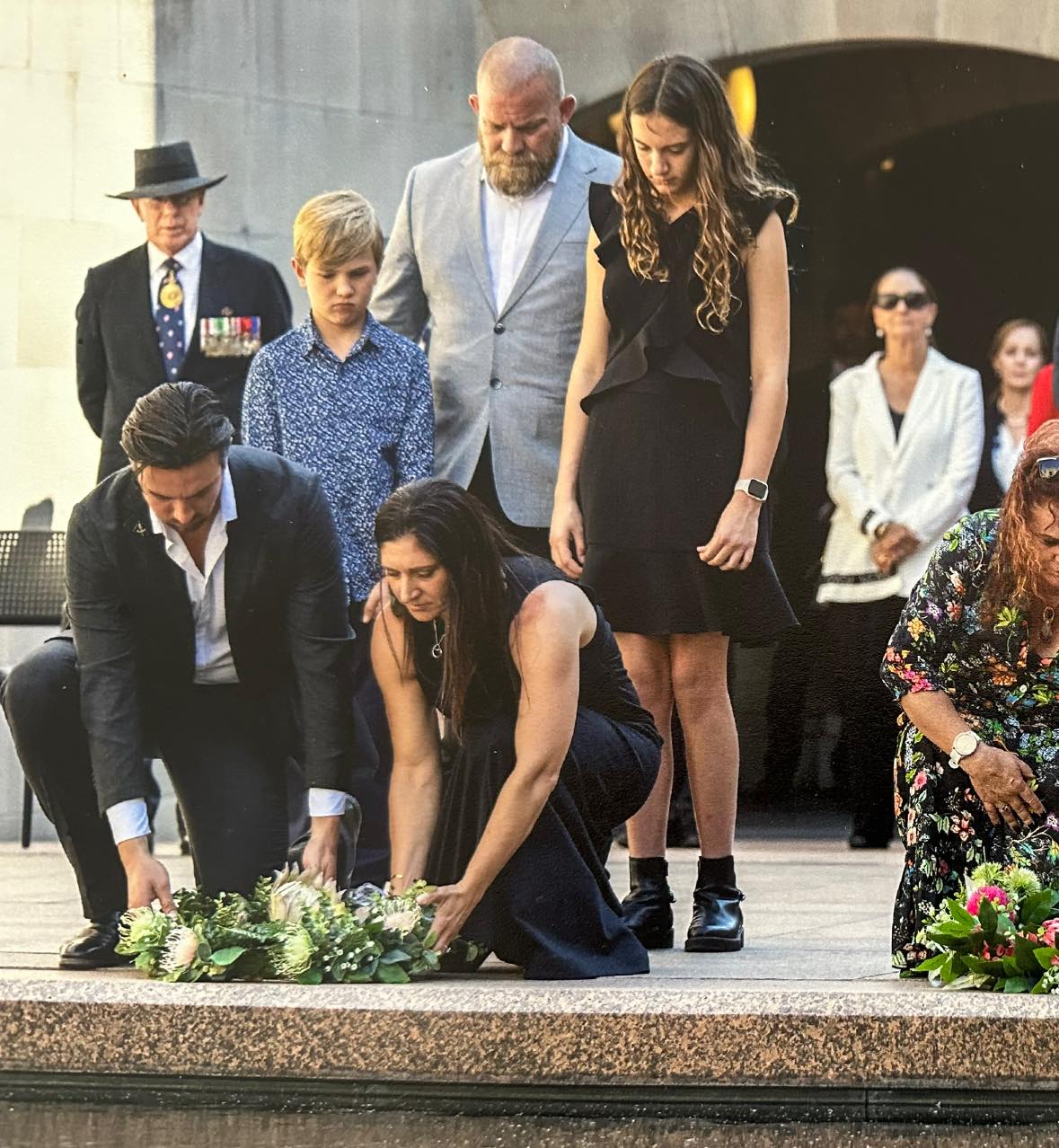 Gwen Cherne paying tribute to her late husband with family at the Australian War Memorial.