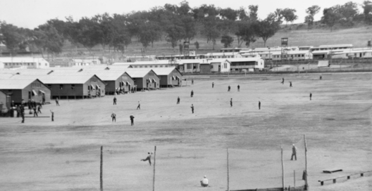 Japanese prisoners of war playing baseball. This photograph was taken for the far eastern liaison office as a basis for propaganda leaflets to be dropped over Japanese held islands during the Second World War. 