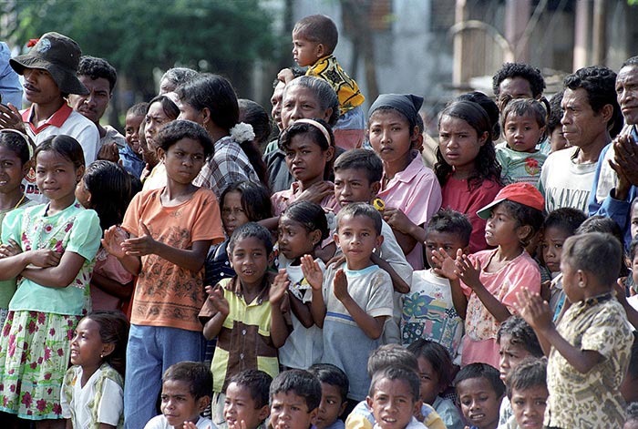 A crowd of East Timor people of various ages. Some are clapping their hands.