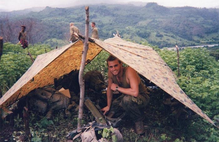 A young smiling soldier in the tent.