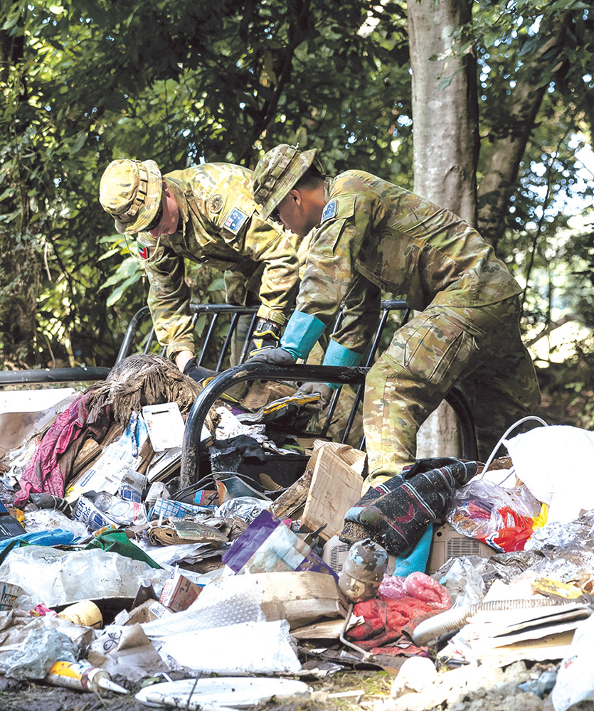 Sapper Kelvin Marquinez from the 5th Engineer Regiment (right) and Private Riva Brown from the Royal New South Wales Regiment assist in the clean-up efforts in Wingham during Operation NSW Flood Assist. Photo: Department of Defence