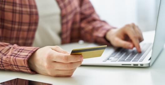 Person paying with debit card while doing online shopping 